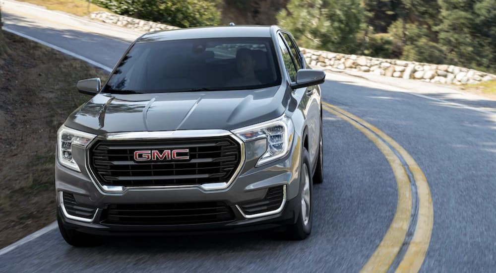 A gray 2023 GMC Terrain Denali driving on a highway.