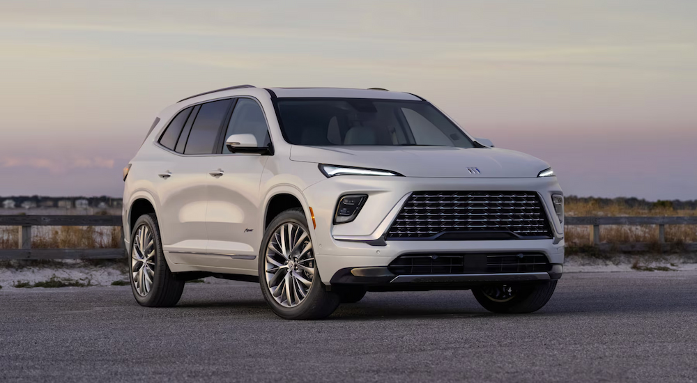 A white 2025 Buick Enclave Avenir parked near water.