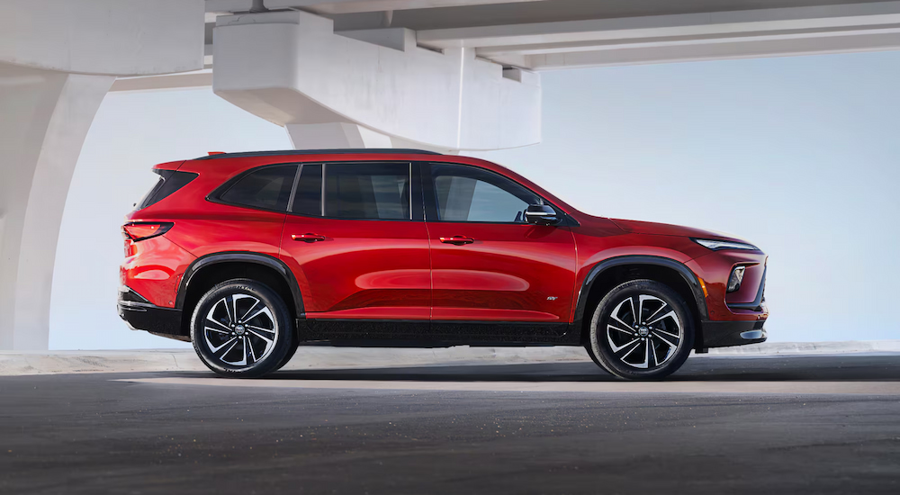 A red 2025 Buick Enclave ST parked under an overpass.