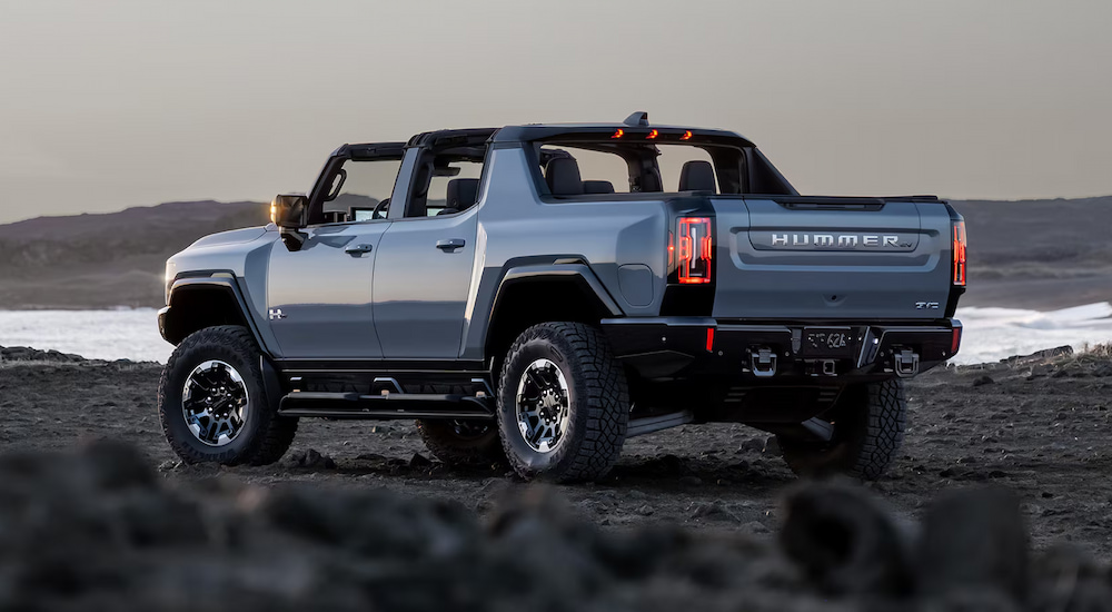 Rear view of a slate blue 2025 GMC Hummer EV Pickup with the roof off.