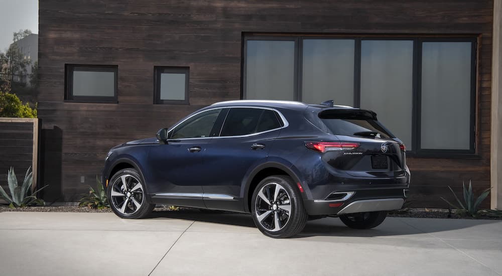 A dark blue 2025 Buick Envision Avenir parked on a driveway,.