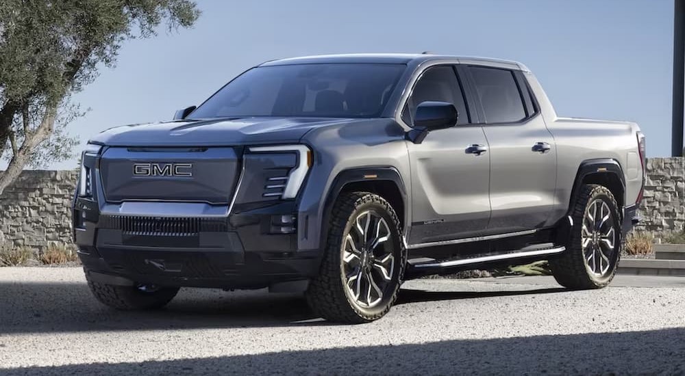 Left angled view of a parked silver 2024 GMC Sierra EV Denali.