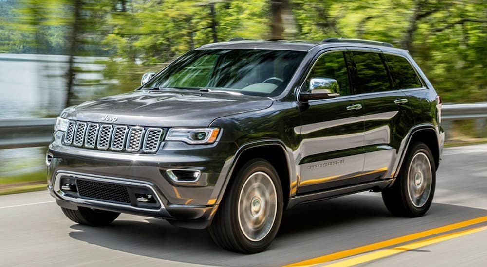 A gray 2020 Jeep Grand Cherokee driving on a highway.