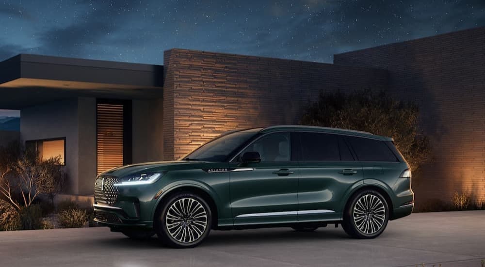 A green 2025 Lincoln Aviator parked near a house.