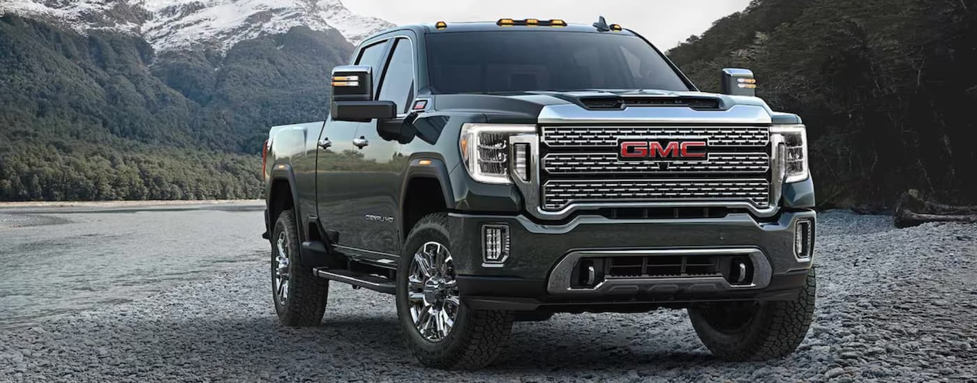 A dark green 2023 GMC Sierra 2500 HD is shown slightly angled and parked off-road.