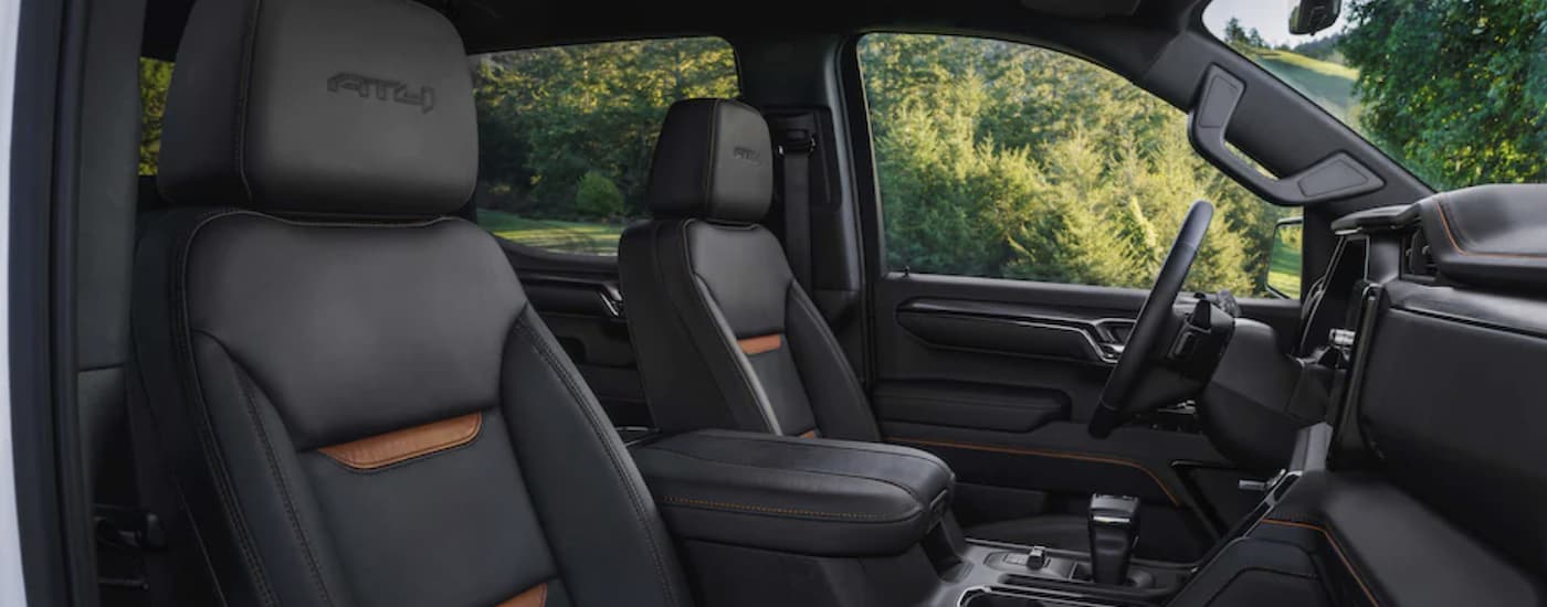 The black interior of a 2023 GMC Sierra 2500 HD AT4 is shown from the passenger side seat.