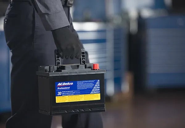 image of a mechanic holding a battery