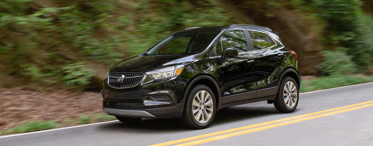 Black 2020 Buick Encore driving down an open road.
