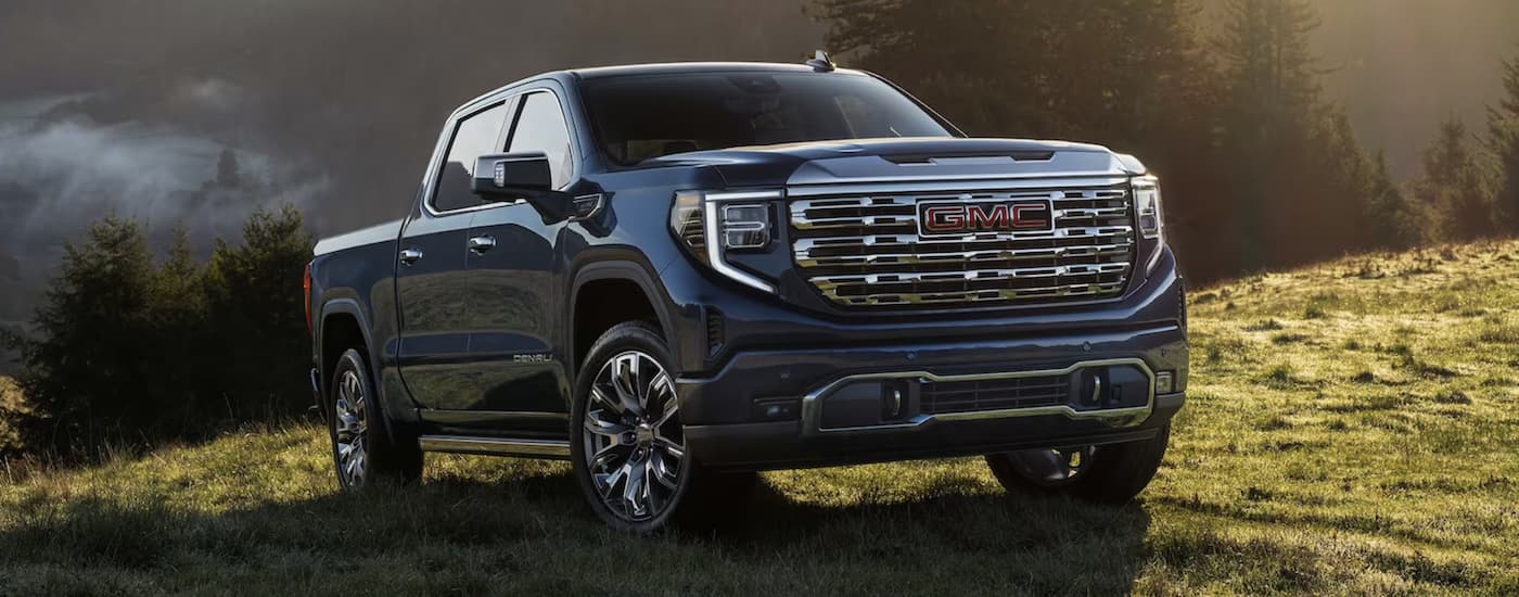 Blue 2023 GMC Sierra 1500 parked off-road.