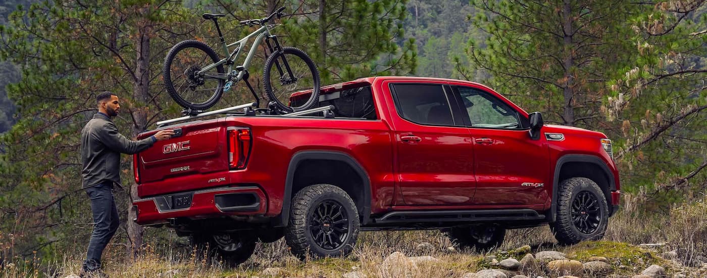 Rear of a red 2023 GMC Sierra 1500 AT4X with a bike mounted in the bed.