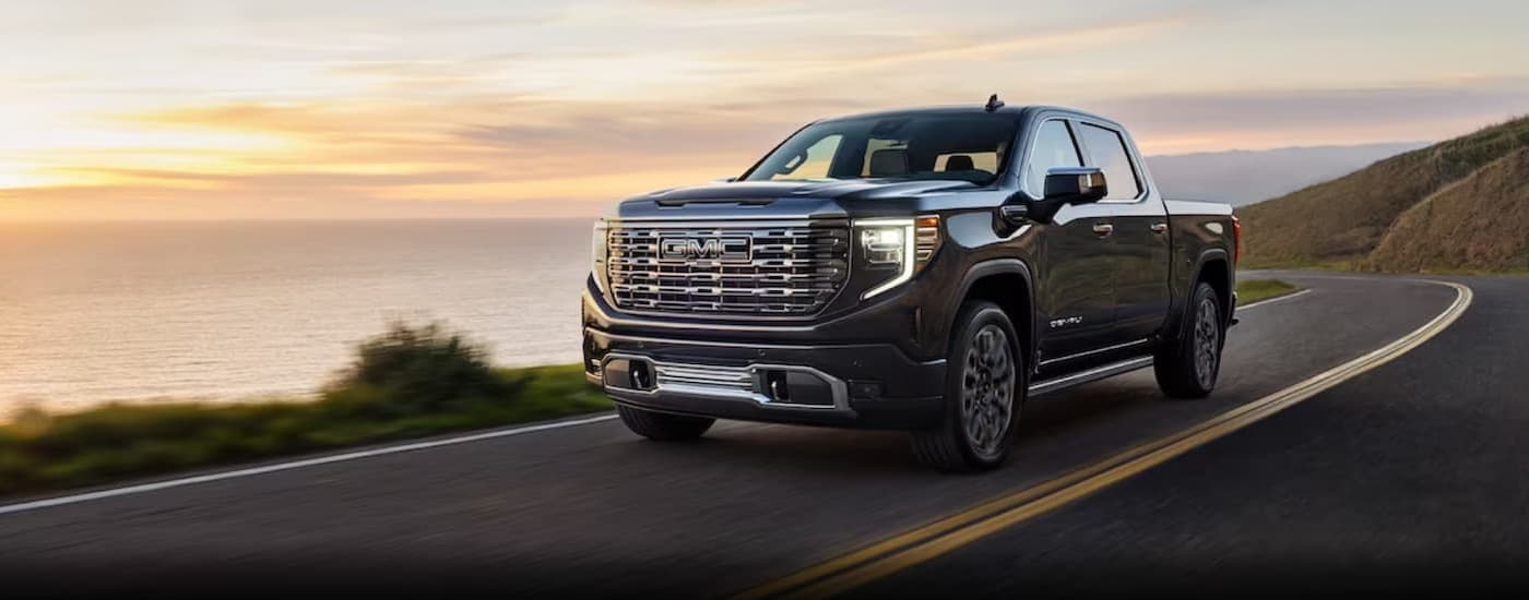 A black 2025 GMC Sierra 1500 for sale near Detroit driving on a highway.