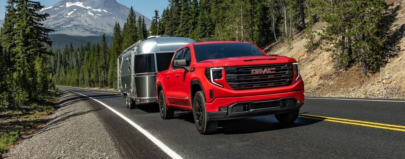 Red 2026 GMC Sierra 1500 Elevation towing a trailer