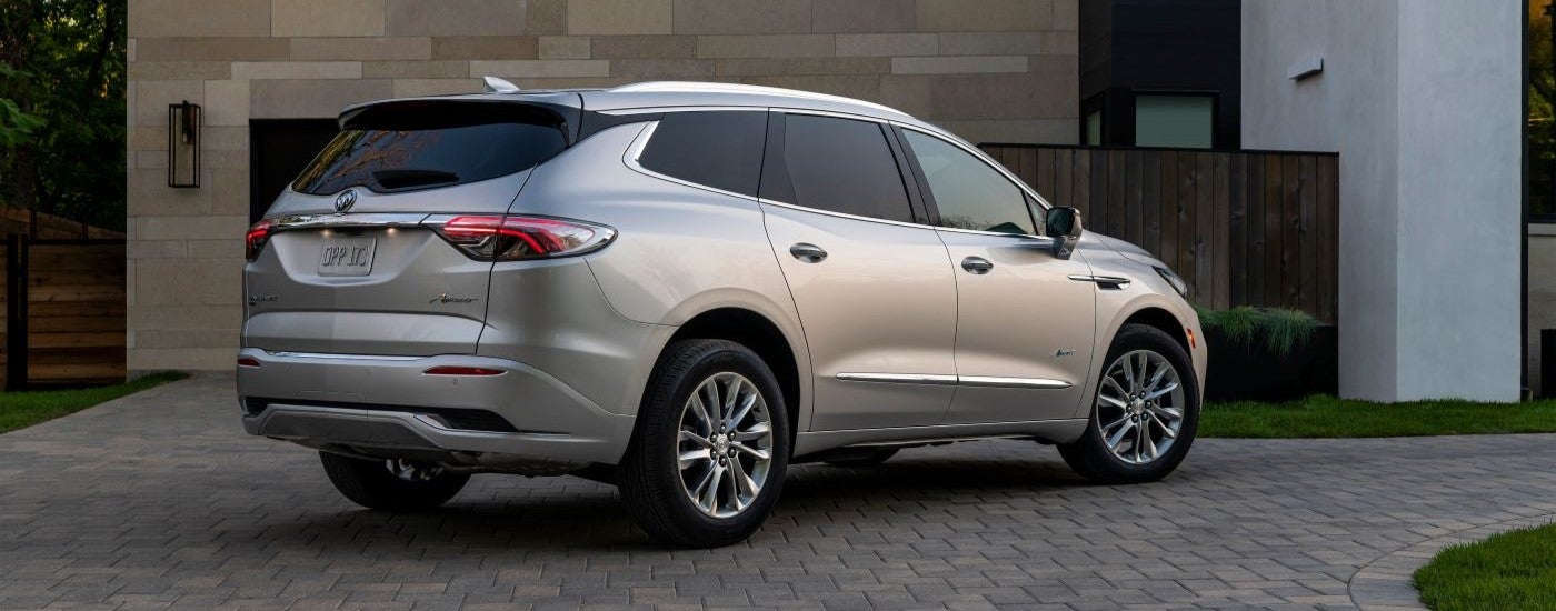 A silver 2022 Buick Enclave Avenir is shown from the rear at an angle.