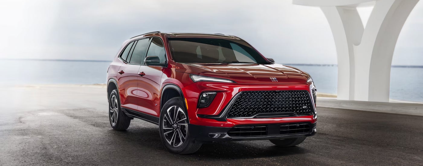 A red 2025 Buick Enclave for sale parked under a white overpass.