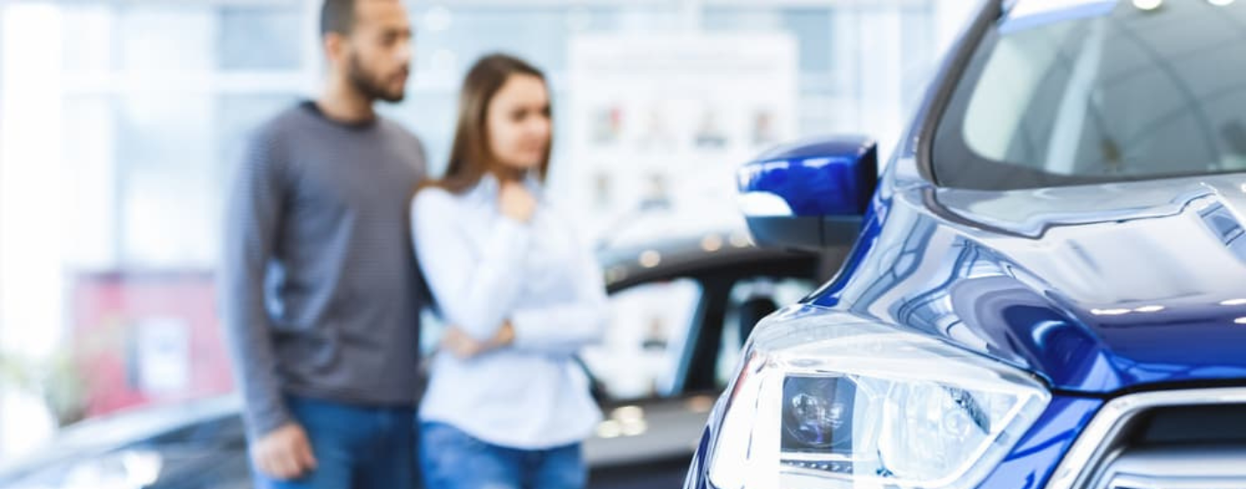 A couple looking at a car at a dealership