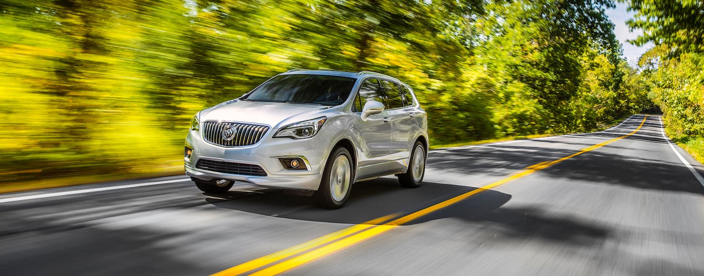White 2017 Buick Envision driving down an open road.