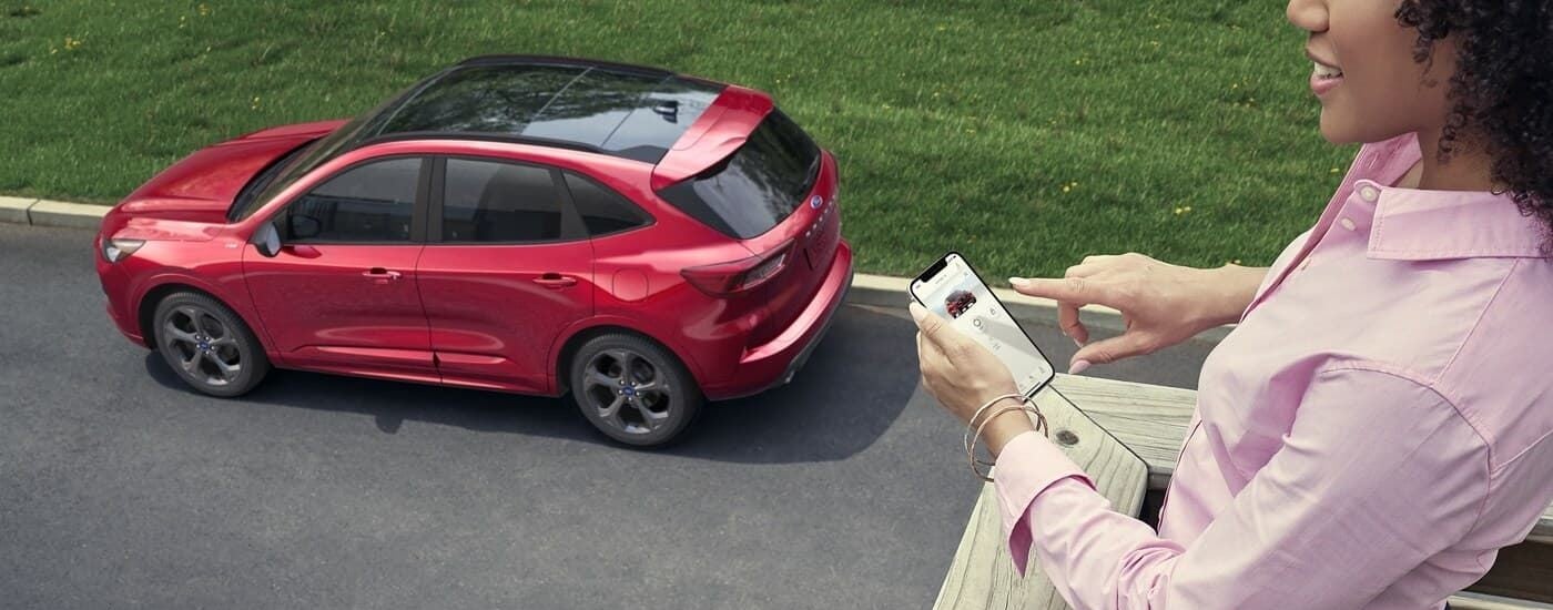 Rear of a red 2023 Ford Escape parked by a curb.